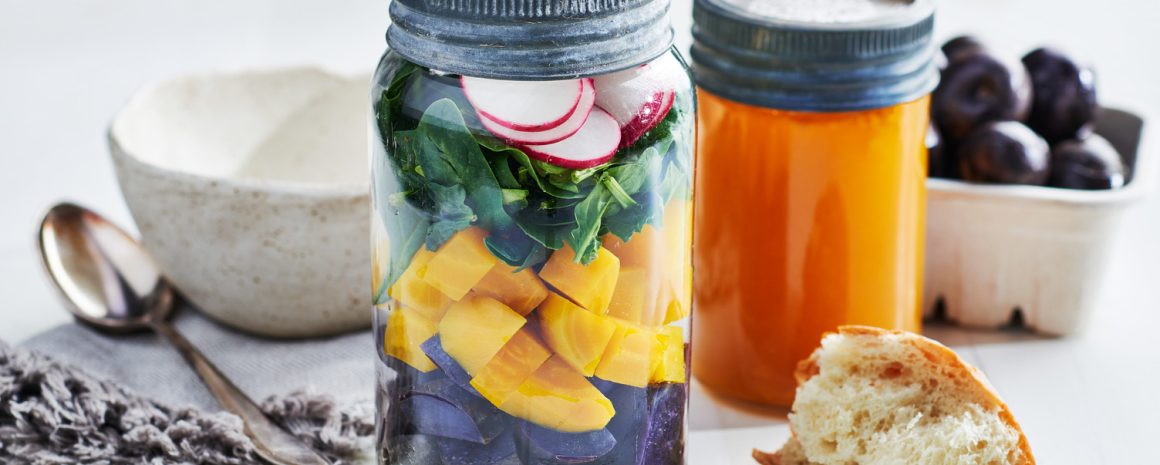 Mason jars with stacked colorful veggies ready to make a tasty soup.