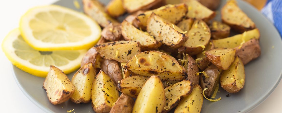 Potato wedges with lemon and pepper on a little plate.
